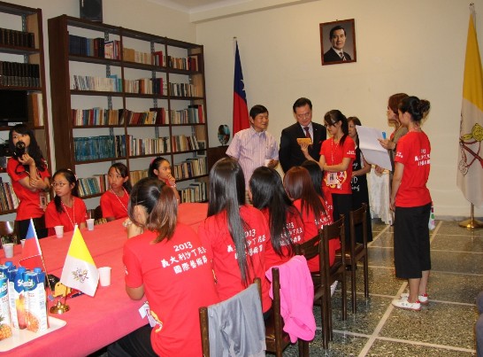 Members of the dancing troupes show a DVD of their performance to Ambassador Larry Wang.