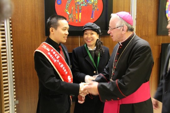 Archbishop Zimowski (right) congratulates Leland (left) for his talent, while his mother stands in the middle.