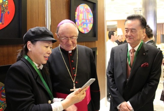 Karen (left) shows an APP on Leland’s paintings to Archbishop Zimowski (middle) and Ambassador Larry Wang (right).
