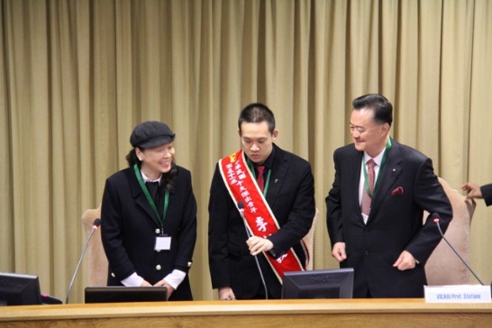 During the Conference, Leland (middle) greets the audience standing next to Ambassador Larry Wang (right) and his mother (left).