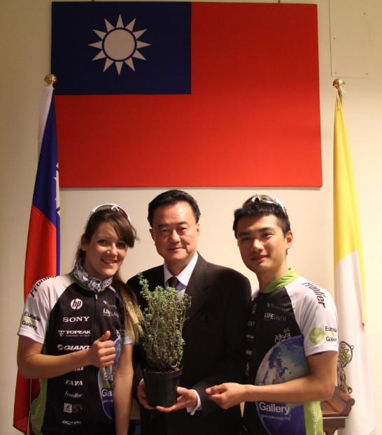 王豫元大使（中）手持「綠色騎跡」單車隊隊員張晏鐘先生（右）及花樂梅女士（左）所贈之麝香草（亦稱百里香，Thyme）盆栽
