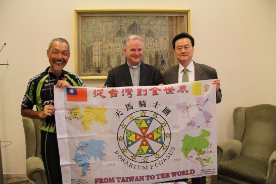 駐教廷大使王豫元（右）與教廷「社會傳播委員會」秘書長Paul Tighe蒙席（中）、環球騎士陳敏先（左）在「社會傳播委員會」會客室共持印有中華民國及教廷國旗之環球行程圖合影