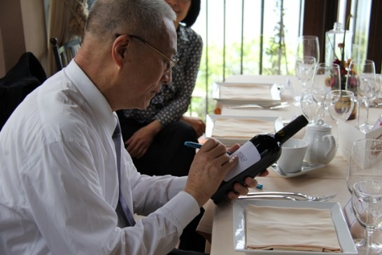 吳副總統應邀在餐廳陳年葡萄酒標籤上簽名留念。