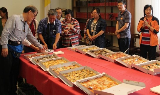 The delegation members enjoy the pizza offered by Ambassador Larry Wang.