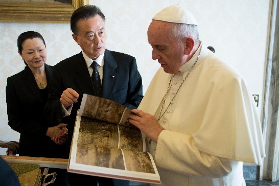 教宗方濟各翻閱郎世寧來華三百年特展專書「神筆丹青」情形