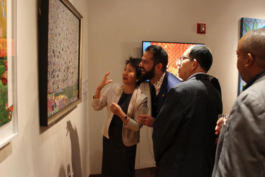Ambassador Lily Hsu (left) explains an artwork to guests attending the reception.