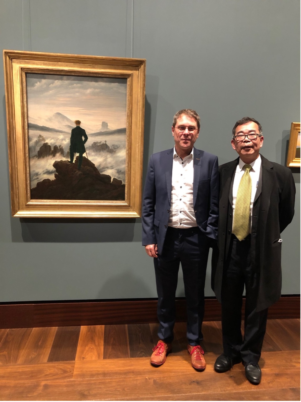 本處陳處長於 11 月 12 日下午前往漢堡美術館(Hamburger Kunsthalle)拜會其館長 Dr. Alexander Klar， 並與來自德國代表處文化組的葉瑋妮組長共同致贈國立台灣美術館印 製的限量年節版畫。圖為 Dr. Klar 向陳處長介紹漢堡美術館鎮館之寶—霧海上的旅人。 該油畫是由德國浪漫主義畫家卡斯帕.大衛.佛里德里希(Caspar David Friedrich) 約於 1818 年在德勒斯登所畫，並在今日被視為德國浪漫主義的代表作。

