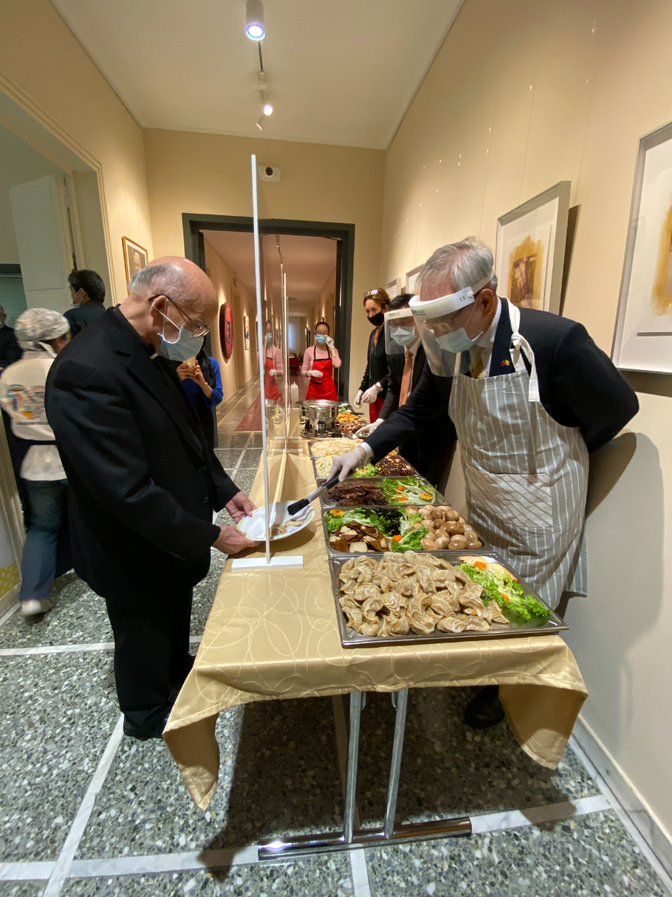 駐教廷大使李世明（右1）全副武裝親自當打菜服務員，替德籍神父彌維禮（左）等曾在台灣服務的神職人員夾菜。