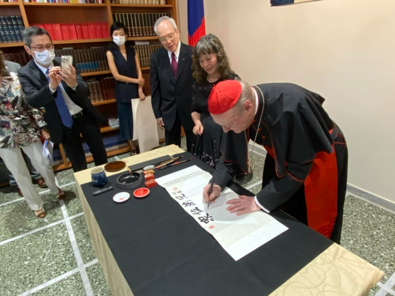      “St. Paul used to say that we must praise God with words, work and lyrics,” said Cardinal Gianfranco Ravasi at the inauguration ceremony of “Friendly Taiwan meets Fratelli tutti” exhibition held on Friday, July 1st, 2022 at the Chancery of the ROC (Taiwan) Embassy to the Holy See. He then added that “The truth conveyed by the contents of Fratelli tutti encourages us to do good but, at the same time, it is also conveyed through the artworks of Taiwanese artists.
Cardinal Ravasi of the Dicastery for Culture and Education opened the exhibition with a prayer as to include the voice of Pope Francis through a passage of Fratelli tutti: “Inspire in us a dream of renewed encounter, dialogue, justice and peace. Move us to create healthier societies and a more dignified world, a world without hunger, poverty, violence and war.”
     Inspired by the Pope’s “Culture of Encounter,” the exhibition features 18 religious calligraphy and 12 calligraphic ink painting works created by well-known Taiwanese American artists Maw Chyuan Wang and Karen Shee. Among the guests, a delegation of authorities from Taiwan, the Holy See, as well as members of the Diplomatic Corps and religious congregations.
     The thirty pieces on display contain excerpts from the Bible and the Pope’s encyclicals Laudatosì and Fratelli tutti,and other inspiring phrases to highlight Taiwan’s commitment and joint efforts with the Holy See to advance global human rights and welfare, democracy, freedom, and environmental protection. As reminded by Ambassador Matthew S.M. LEE: “The similarities between Taiwan and the Holy See are not only in the forms of artistic expression, but also in the values shared by both sides: democracy, freedom, and human rights.” 
     “Friendly Taiwan meets Fratelli tutti” exhibition celebrates the 80th anniversary of diplomatic relations between the Republic of China (Taiwan) and the Holy See by combining the Sacred Scripture with the beauty of Taiwanese calligraphy to give the audience an original and innovative experience. 

