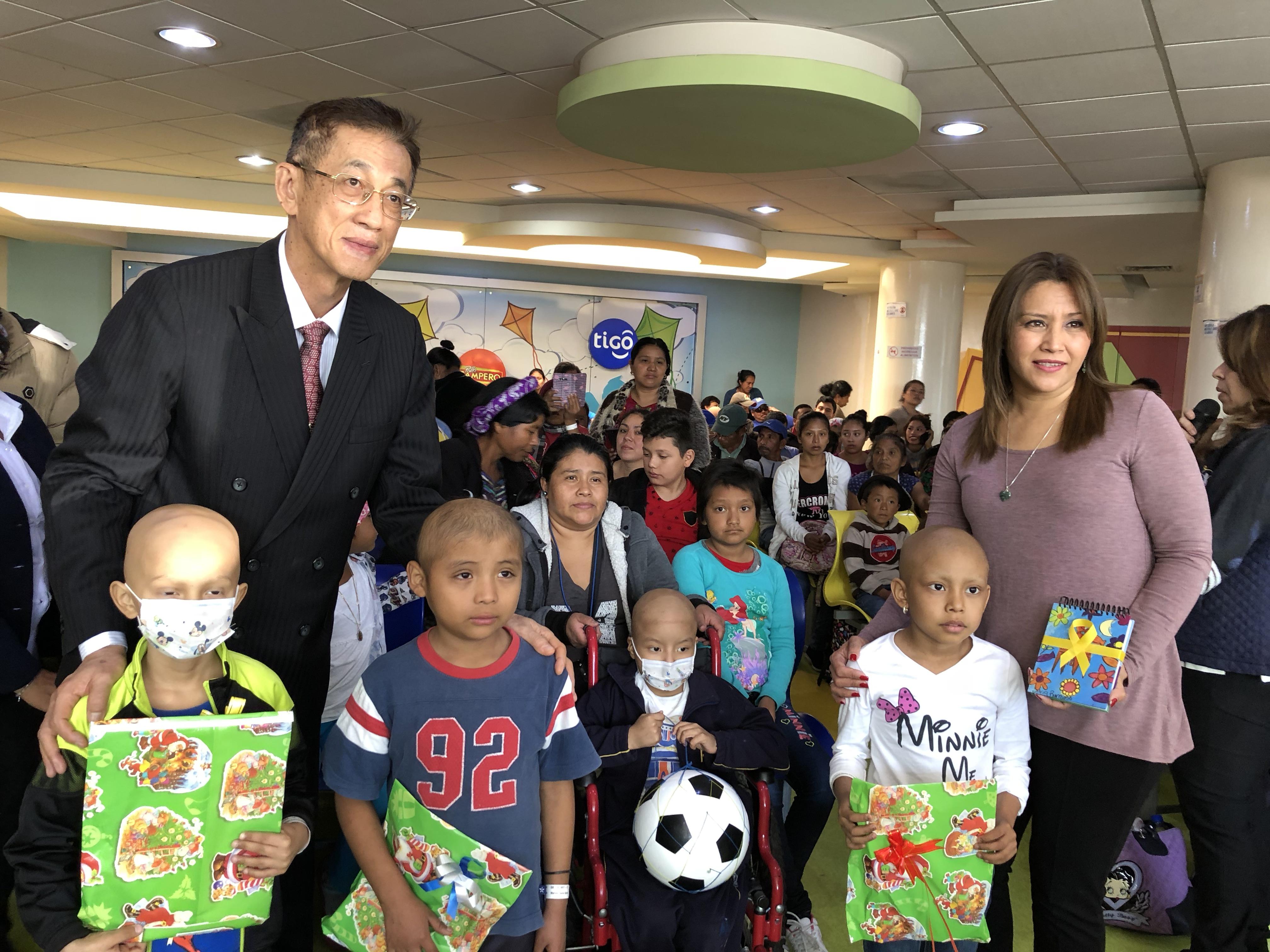 賴大使(左後一)及瓜國第一夫人(右後一)與病童合影