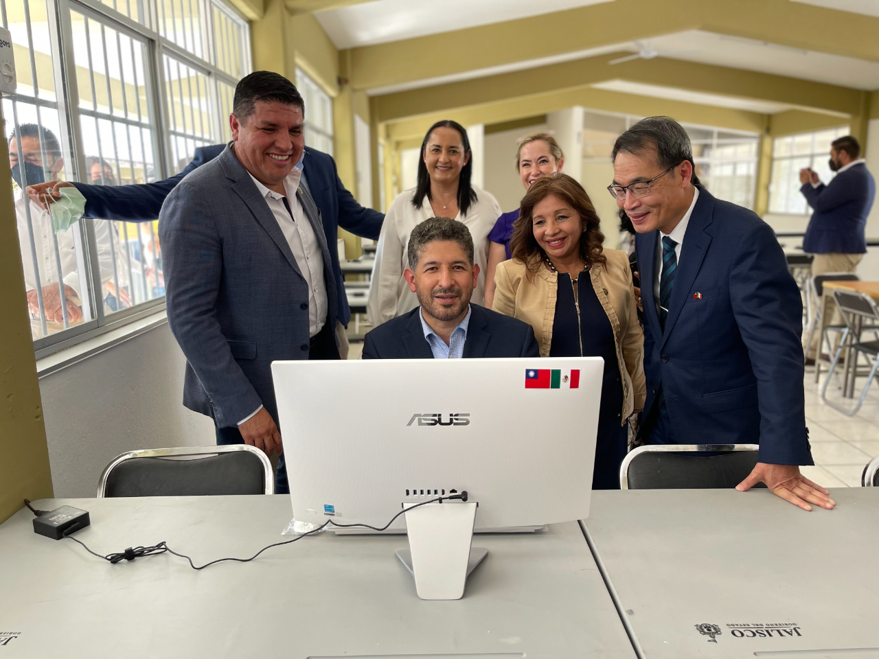 鄭代表與哈里斯可州教育廳廳長佛洛雷斯（中坐者）、聯邦眾議員瑪汀內絲（前右2）、阿美卡市市長塞拉諾（左1）及該市市議員於我捐贈「華碩電腦」所設立的電腦教室內合影