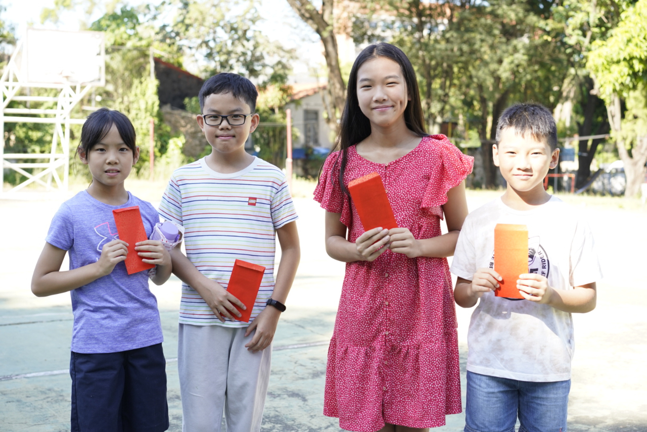 參加升旗典禮12歲以下孩童領到由中華會館準備的新年紅包，新年學業成績將更進步。