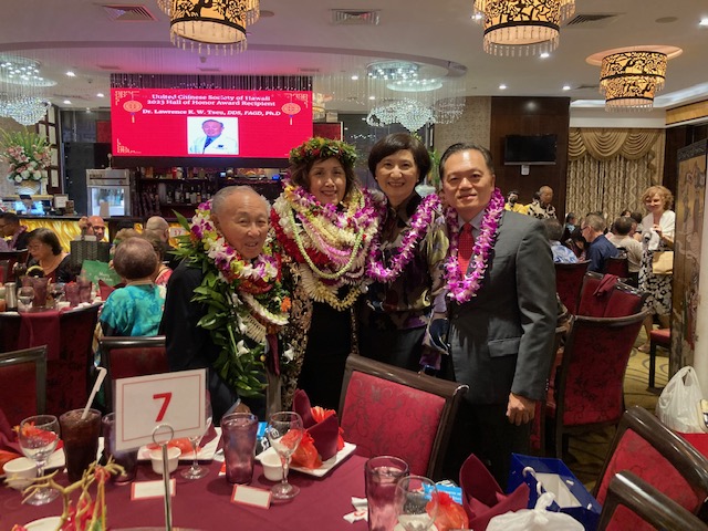 2023年12月3日林處長暉程夫婦應邀出席夏威夷中華總會館2024年新任職員交接晚宴, 向候任會長蔡梅麗(左2)及2023年名人堂得獎人鄒錦榮博士(左1)致贈花環(lei)道賀.