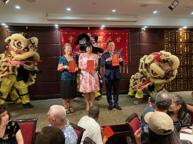 2024年5月11日林處長暉程(右)於甘氏同宗親會晚宴舞獅採青儀式中與會長Wendy Mao(中),副會長Lynette Kam (左) 同向來賓祝賀新年龍馬精神˴好運龍來