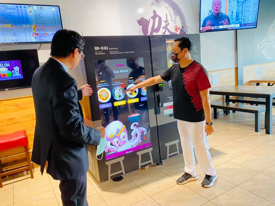 功夫茶負責人周文博向駐休士頓台北經文處羅復文處長示範自動拉麵機點餐