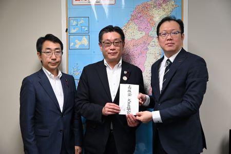 東京都大田區議會議長押見隆太（照片中央)與議會副議長秋成靖（左)將東京都大田區議會捐贈善款目錄交給駐日本代表處政務組長傅國華(右)