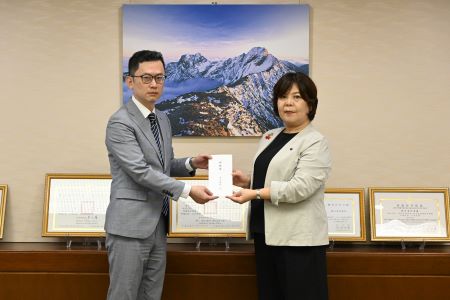 山形縣東京事務所所長黑田步美（照片右)將山形縣民捐贈善款目錄交給駐日本代表處政務組副組長林冠宏(左)。