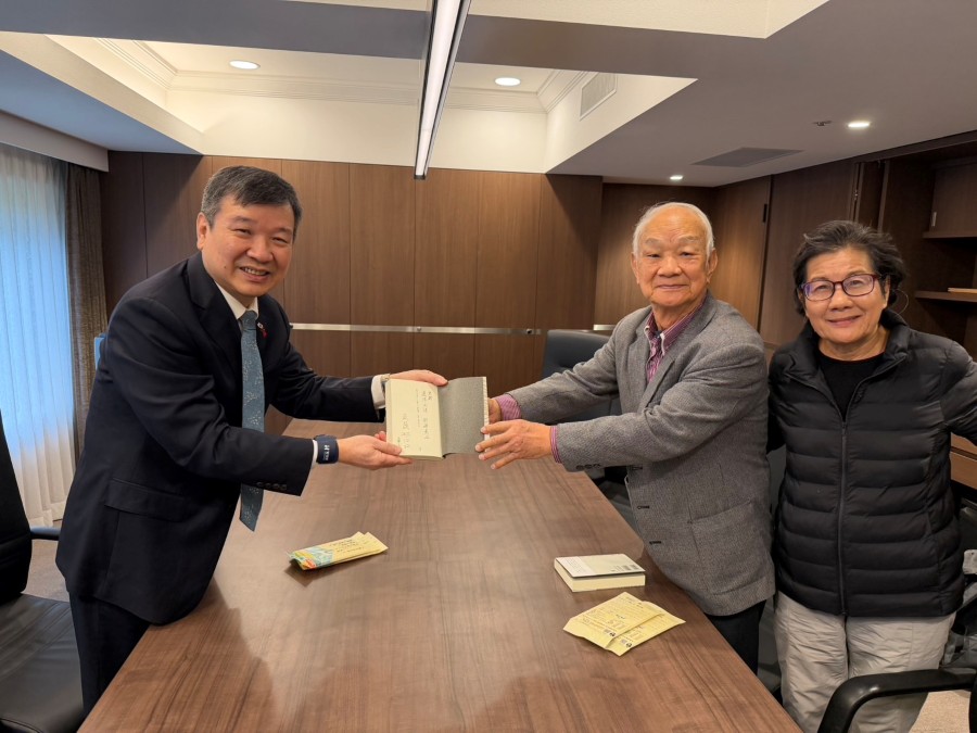 總統府資政、台灣詩人吳晟的詩集《他還年輕》，由日本思潮社首度翻譯完整詩集出版，12月20日(六)在台灣文化中心辦理發表新書發表暨座談會。駐日代表李逸洋大使特地親往吳晟下塌飯店致意，並就台日文學交流交換意見。
照片：吳晟（右2）致贈《他還年輕》日譯詩集給李逸洋大使（左）。