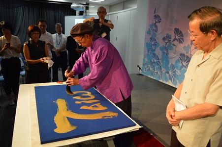 「Taiwan」と揮毫する徐永進さん（中央）と謝長廷・駐日代表（右）