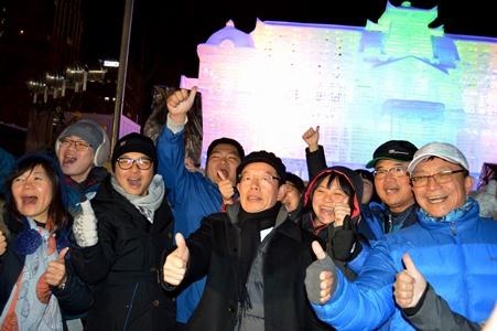 ライトアップされた「台湾―台北賓館」氷像をバックに謝長廷・駐日代表（中央）と台湾からの観光客ら