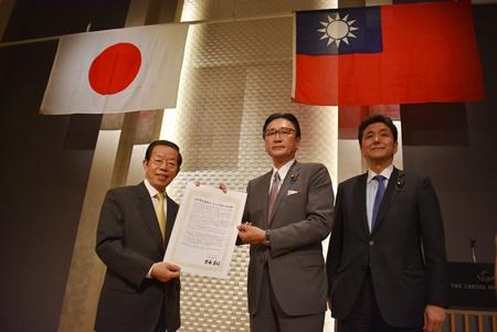 会長の古屋圭司・衆議院議員（写真中央）から、台湾のCPTPP協定への加入、WHOおよびWHO総会への参加、ICAOおよびICPOなど国連機関への参加、国連のSDGsに基づいた国際貢献などを支持する内容の「日華議員懇談会2019年度方針決議」の書面を手交される謝長廷・駐日代表（左）。同懇談会幹事長の岸信夫・衆議院議員（右）。

