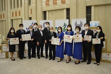 張仁久・駐日副代表（左６）および東京都議会日台友好議員連盟の高橋信博会長（左５）、三宅正彦・事務局長（右２）、鈴木隆道・顧問（前議員）（左３）が立会いの下、多羅尾光睦・東京都副知事（右６）にマスクや防護服等の防疫物資の寄贈目録を手渡す世界華人工商婦女企管協会日本分会の銭妙玲会長（右５）と東京台湾商工会の陳五福会長（左２）。
