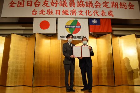 永井啓介・大阪市議会議員（左）より台湾のWHO（世界保健機関）参加を支持する「全国日台友好議員協議会」決議文を受け取る謝長廷・駐日代表（右）