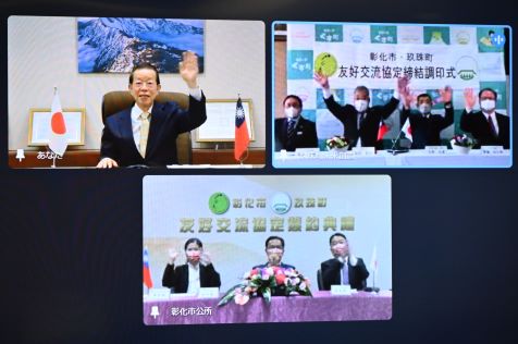 謝長廷・駐日代表（スクリーン左上）、林世賢・彰化県彰化市長（スクリーン下、中央）、宿利政和・大分県玖珠町長（スクリーン右上、左２）