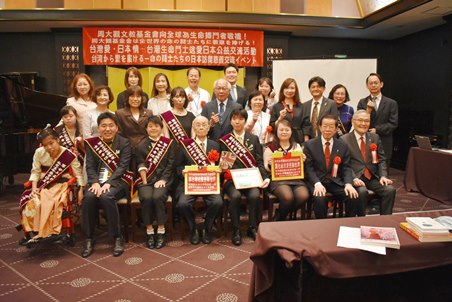 謝長廷・駐日代表（前列右2）、「財団法人周大観文教基金会」創設者の周進華氏（3列目右3）。同基金会から第26回「生命熱愛奨（全球熱愛生命奨章）」を贈られた寿司職人の小野次郎氏（前列右5）、自閉症のピアニストKohya Suechika[末近功也]氏(前列右4)。贈呈式には郭盈蘭・周大観文教基金会董事長（2列目右5）、許詩典・聯新国際病院院長（2列目右6）、張瀞文・聯新国際医療グループ運営長（2列目右4）、日本の「公益財団法人がんの子どもを守る会」の山下公輔・理事長（前列右１）らが出席した。
贈呈式後にはKohya Suechika氏をはじめ、これまでに同奨を受賞したことのある台湾と日本の受賞者らがそれぞれピアノやサクソフォーンなどを披露した。
