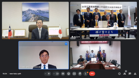 謝長廷・駐日代表（スクリーン左上）、呉萬徳・花蓮県瑞穂郷長（スクリーン右下の前列右２）、横山茂・北海道沼田町長（スクリーン右上の前列右）、粘信士・駐日代表処札幌分処処長（スクリーン右上の前列左）