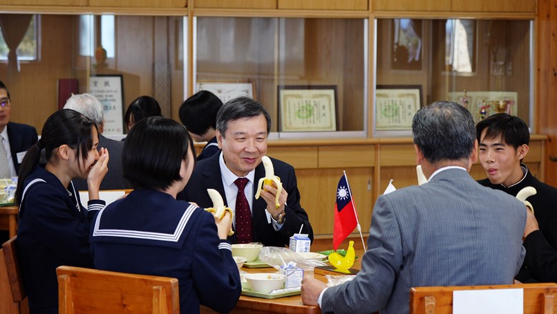 生徒や仙﨑光・那珂市長らと台湾バナナを味わう李逸洋・駐日代表（正面）
