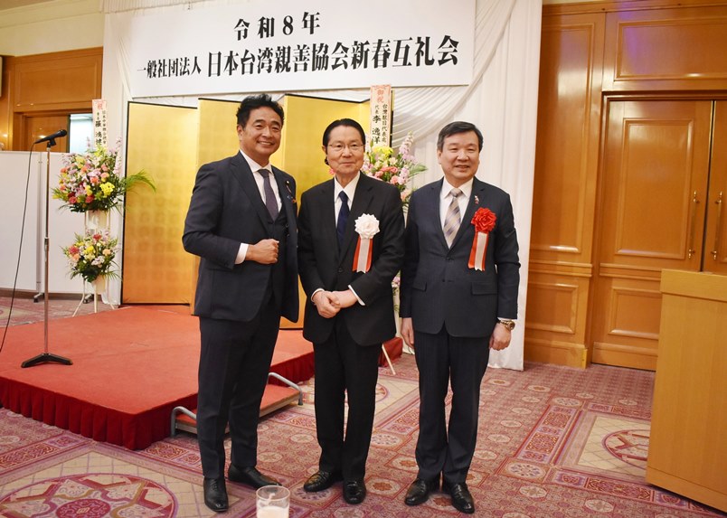 台北駐日経済文化代表処の李逸洋代表は2月10日、「一般社団法人日本台湾親善協会」が都内のホテルで開催した「令和8年　新春互礼会」に出席した。あいさつの中で李・駐日代表は、日本が近年、中国による経済的圧力やサプライチェーンのリスクに直面していることついて言及し、「中国は日本に対し軍民両用品目について輸出を禁止しており、レアアースは影響が大きい分野だ。日本経済は中国への依存を減らし、より安全で強靭な道を進む必要がある。中国依存の経済に戻れば、日本経済の大きな発展はない」との見方を示した。
写真：右より、李逸洋・駐日代表、衛藤征士郎・日本台湾親善協会会長、松下新平・参議院議員