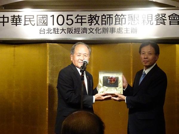 2.陳處長轉頒僑委會致贈大阪中華學校羅理事長辰雄水晶獎座（由洪理事長代行接受）