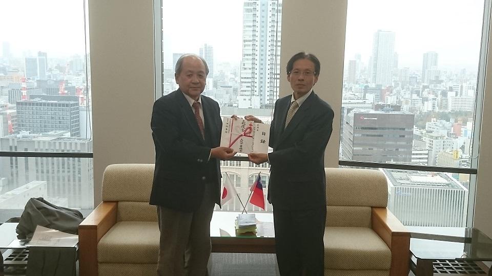 駐大阪辦事處陳處長（右一）接受中華民國留日大阪華僑總會會長洪里勝信（左一）捐贈花蓮地震賑災款