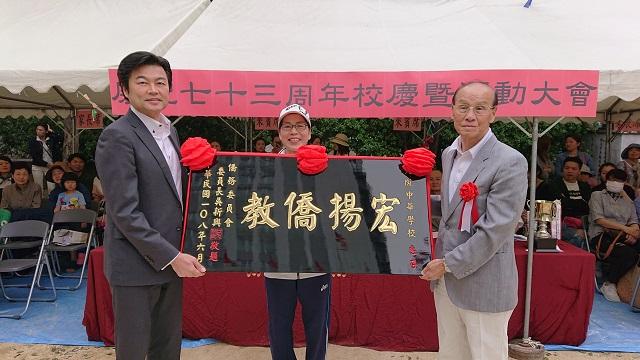 李世丙・処長（左）が吳新興・僑務委員会委員長を代表し大阪中華学校に「宏揚僑教」の扁額を贈呈，連茂雄・理事長（右）、陳雪霞・校長（中央）が受け取る