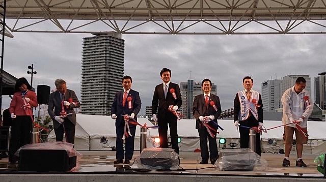 李処長(中央)、陸超会長(左2)、寺崎秀俊副市長(左3)、安達和彥議長(右3)、徐銀樹理事長(右2)ら貴賓がテープカット