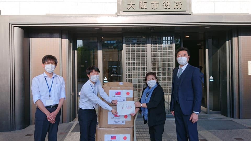 川野女史（右二）が布製マスクを寄贈、李処長（右一）が立ち合った