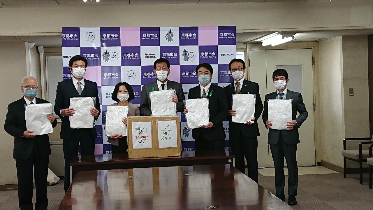 荘子慧玲会長（左3）が医療用防護服を京都市へ寄贈。山本恵一議長（中）が代表として受理。寺田一博会長（右3）、李処長（左2）、黄俊清医師（左1）らが立ち合った。

