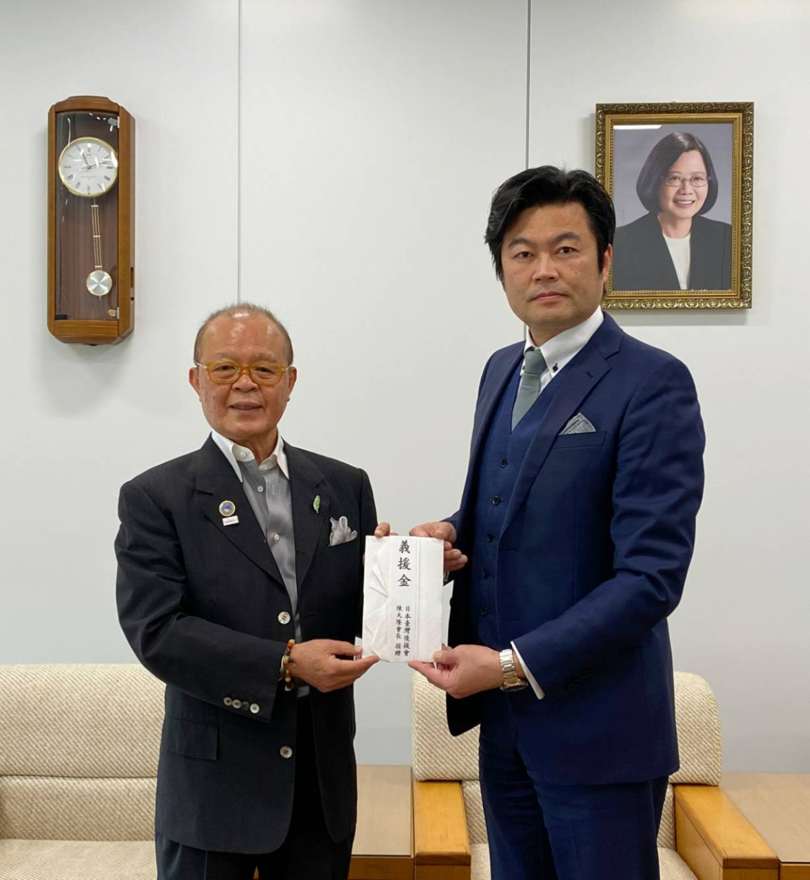 李世丙処長（右）が代表し、陳天隆会長（左）より寄付金を受理