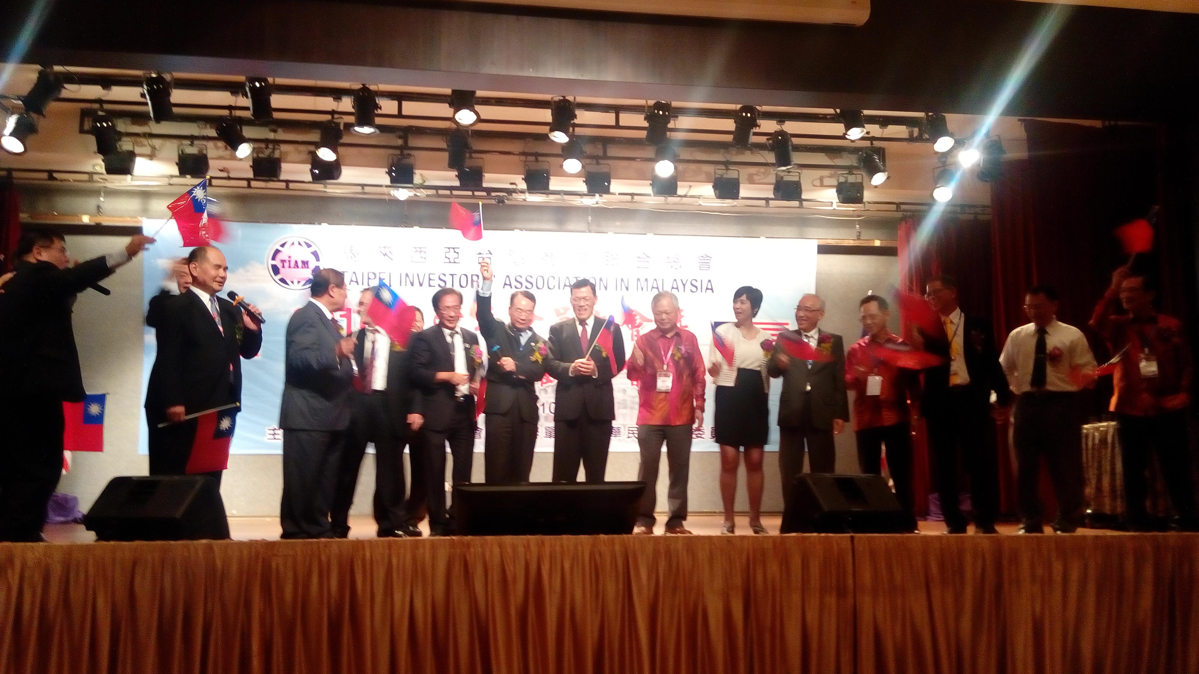 章大使計平(左7)出席馬來西亞臺灣商會聯合總會「慶祝中華民國105年國慶」晚宴和與會貴賓揮舞國旗慶賀。