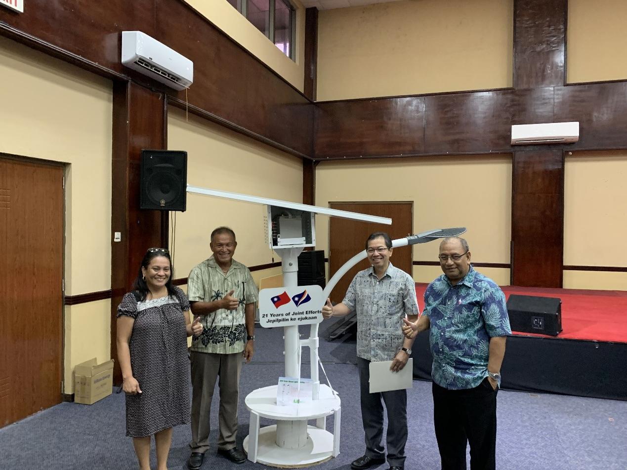 A solar streetlight Sample with the billboard shows two countries national flags and the Love from Taiwan. From the right: Hon. Minister of the assistant to the President Christopher J. Loeak, Ambassador Jeffery S.C. Hsiao, H.E. President David Kabua, and  Angeline Heine, Director of the National Energy Office.