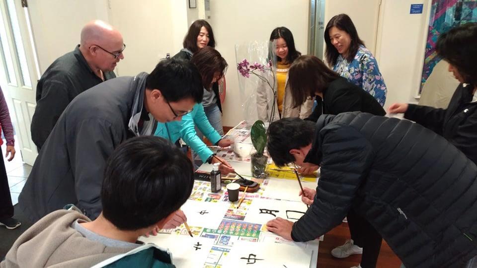 僑胞揮毫參與餐會後的書法競賽