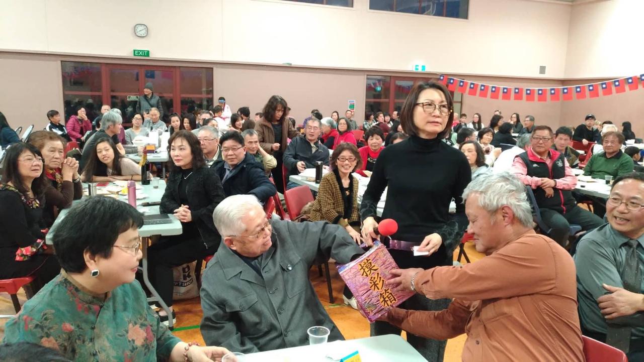 <code></code>除各種表演外，現場亦有摸彩活動，圖為活動主持人華興協會林貝兒理事(中間右立)請基督城人瑞書法家湯于勳先生(中間左)抽獎