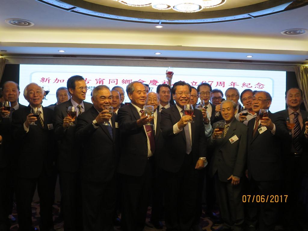 駐新加坡台北代表處代表梁國新(右4)、副代表戴輝源(左3)應邀與新加坡古甯同鄉會會長李財豐(左5)、副會長李志遠(左4)及其他理事一齊上台「飲勝」祝酒。（106年6月7日)