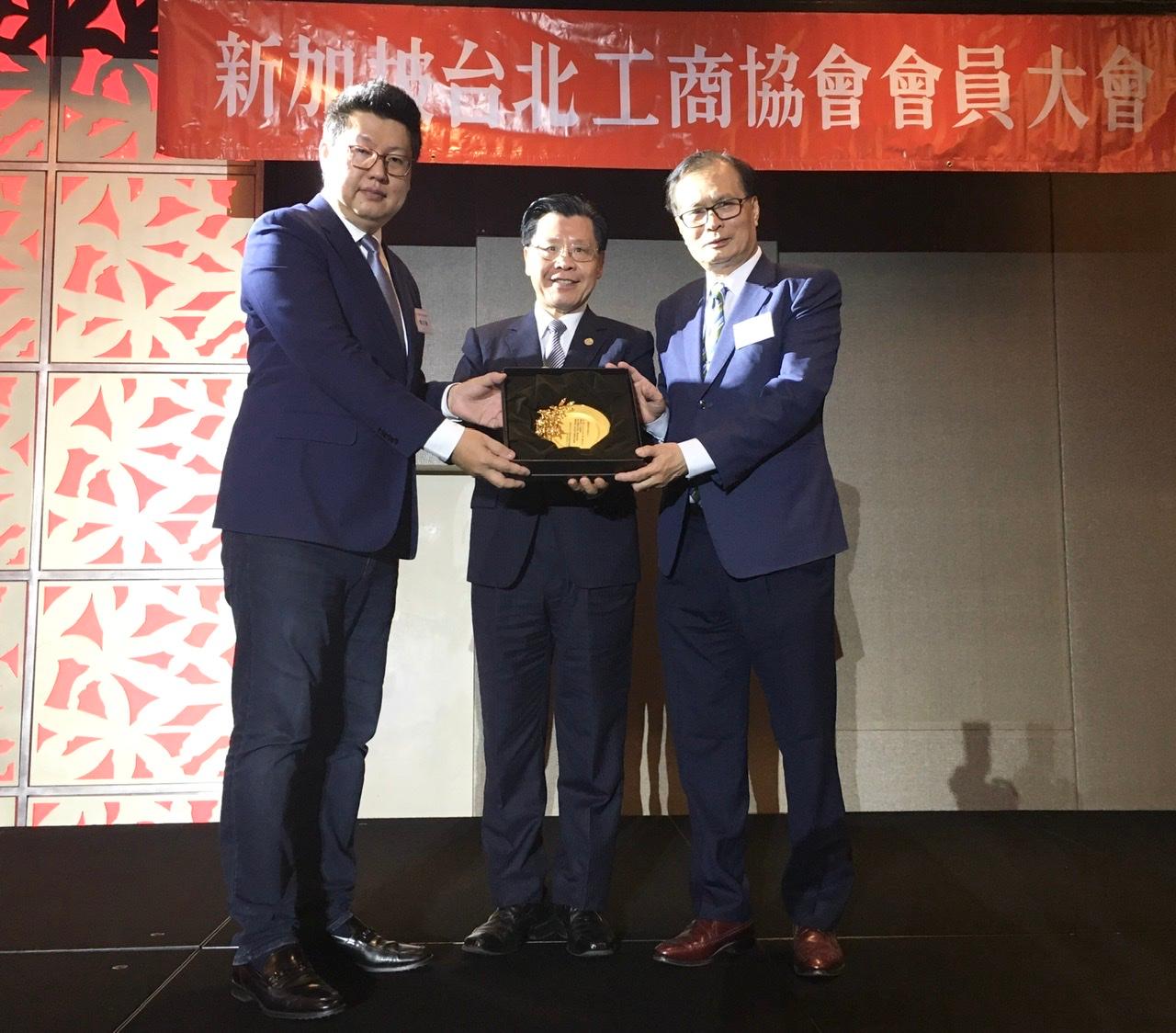 新任會長楊正祺(左)致贈紀念品給名譽會長施至隆(右)，中間為駐新加坡台北代表處代表梁國新。 (109/01/18)