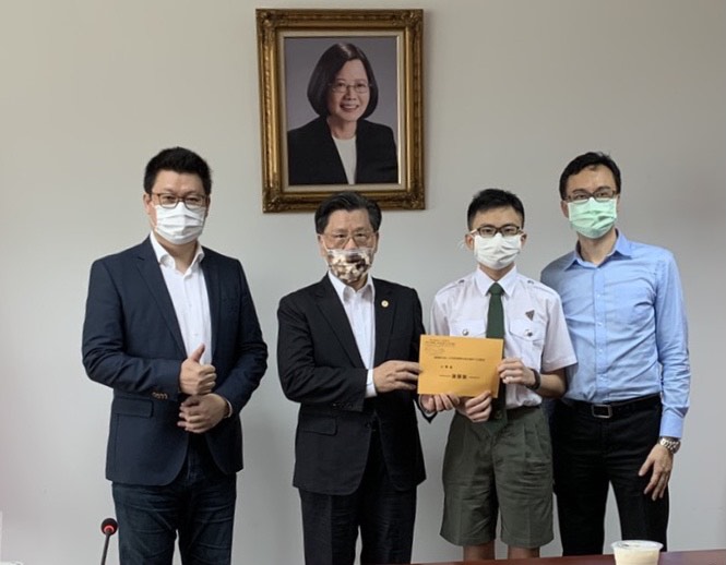 梁代表頒贈獎勵金予小學組受獎者謝騏駿同學(右一為家長謝承憲教授，左一為楊會長正祺)。