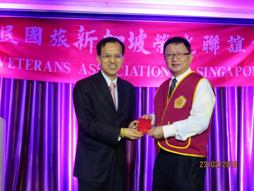 Deputy Representative Steven Tai (left) handing the check for the grant by the Veteran Affairs Council to the chairman of the  R.O.C. Veterans Association in Singapore.