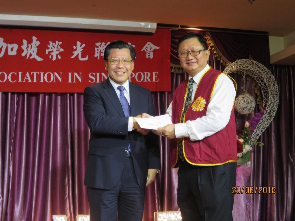 Representative Liang (Left) presenting a check from the Veteran Affairs Council, R.O.C. to Mr. Ko Chaw Chung, the chairman of the R.O.C. Veterans Association in Singapore.