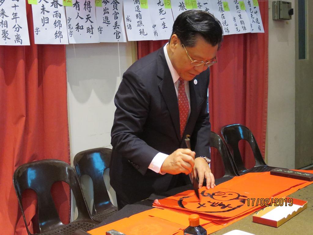 Representative Francis Liang writing his Chinese New Year message on red paper at the 2019 ATUC Lunar New Year gathering.