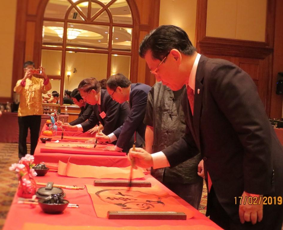 Representative Francis Liang (extreme right) joining other distinguished guests in the writing of auspicious messages on red paper to usher in the New Year.